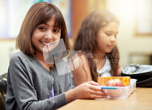 Image of Girl, smile and portrait with lunch at school for recess, break or nutrition at table with meal. Kid, face and happy at academy or relax with confidence, food and pride for childhood development