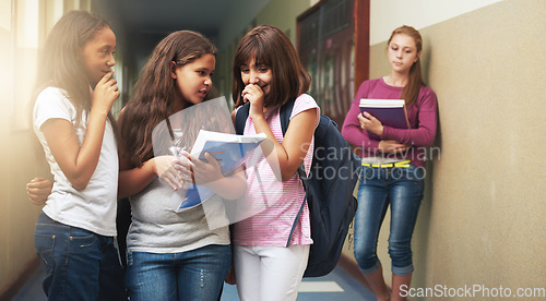 Image of Girls, school and bullying student in gossip, secret or whisper down the corridor or hallway. Group of young kids or children teasing and laughing by lonely learner in verbal abuse outside classroom