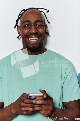 Image of African American teenager engages with his smartphone against a pristine white background, encapsulating the essence of contemporary digital connectivity and youth culture