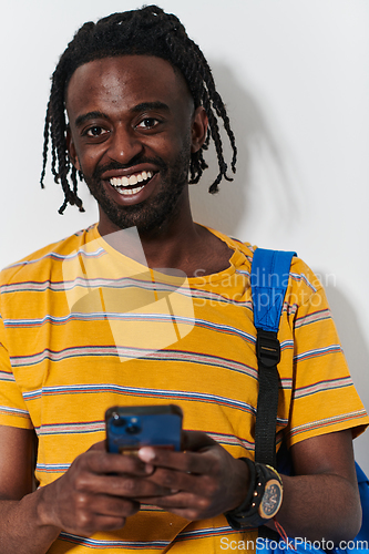 Image of African American teenager engages with his smartphone against a pristine white background, encapsulating the essence of contemporary digital connectivity and youth culture