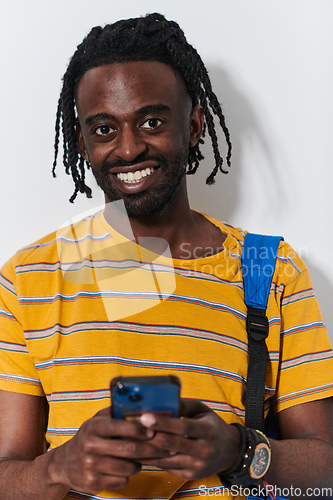 Image of African American teenager engages with his smartphone against a pristine white background, encapsulating the essence of contemporary digital connectivity and youth culture