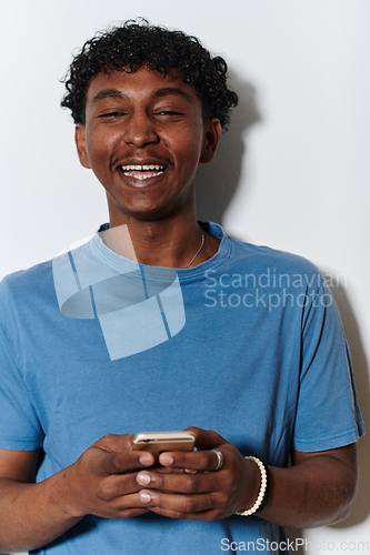 Image of African American teenager engages with his smartphone against a pristine white background, encapsulating the essence of contemporary digital connectivity and youth culture