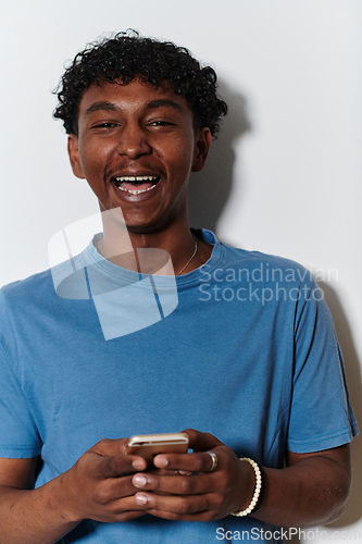 Image of African American teenager engages with his smartphone against a pristine white background, encapsulating the essence of contemporary digital connectivity and youth culture