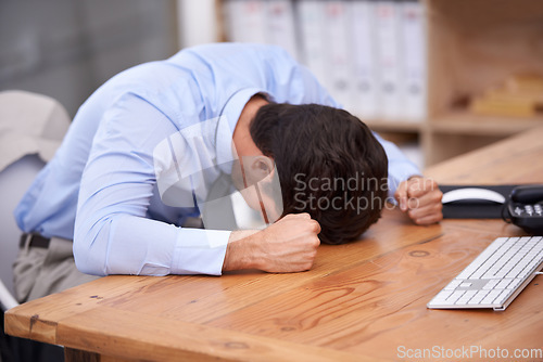 Image of Business man, stress and resting on desk, burnout and mental health or overworked in workplace. Male professional, frustration and banging table in anger, bankrupt and overwhelming debt or pressure