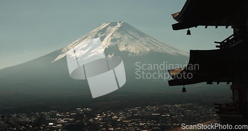 Image of Chureito Pagoda, Mount Fuji and city in morning with temple, trees and blue sky on travel. Japanese architecture, culture and spiritual history with view of mountain, snow and calm Asian landscape.