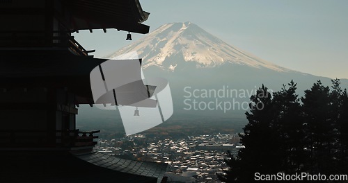 Image of Chureito Pagoda, Mount Fuji and view of city in morning with temple, trees and blue sky on travel. Japanese architecture, culture and spiritual history with mountain, snow and calm Asian landscape.