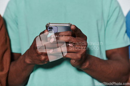 Image of African American teenager engages with his smartphone against a pristine white background, encapsulating the essence of contemporary digital connectivity and youth culture