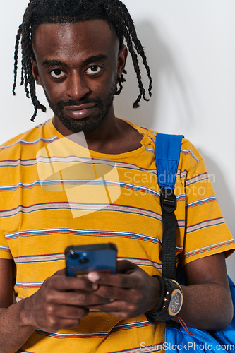 Image of African American teenager engages with his smartphone against a pristine white background, encapsulating the essence of contemporary digital connectivity and youth culture