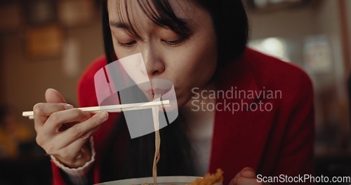 Image of Woman, ramen and eating noodles in restaurant for nutrition, healthy meal and diet. Hungry lady, chopsticks and spaghetti for lunch, dinner and Japanese cuisine in cafeteria, diner and fast food menu