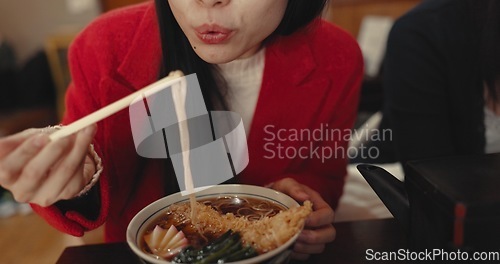 Image of Woman, mouth and blowing ramen noodles in restaurant for dinner, diet and meal in cafeteria. Closeup, hungry lady and chopsticks for eating hot spaghetti, Japanese cuisine or lunch in fast food diner