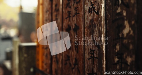 Image of Japan, writing and wood with Japanese, spiritual and pillars with sign on a urban road outdoor. Travel, path and Asian culture with ancient structure with history in Hanamikoji Street in Kyoto