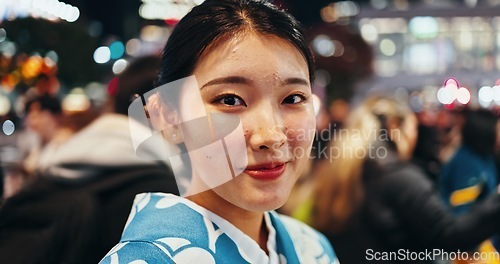 Image of Japanese woman, portrait and night in city, busy urban street or crowd on commute, walk and outdoor. Girl, person and happy for vacation, exploring or journey on metro sidewalk for adventure in Tokyo