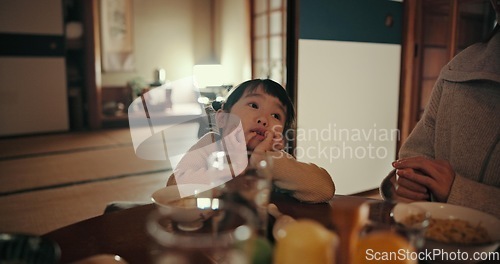 Image of Asian child, family home and bored at dinner with parents for food, tired or night in dining room. Japanese kid, nutrition and diet with thinking, annoyed or frustrated by table at apartment in Tokyo