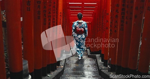 Image of Woman, shinto religion and walk by gates in japan, spiritual path and indigenous culture in kimono. Person, traditional clothes or worship in peace, respect or beauty by Fushimi Inari Taisha in kyoto