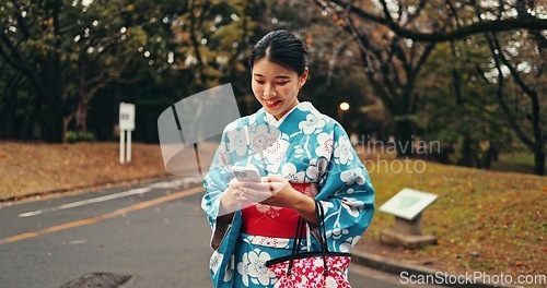 Image of City, phone and Japanese woman in street for online networking, website and social media. Travel, walking and happy person typing on smartphone with traditional fashion, culture and kimono in nature
