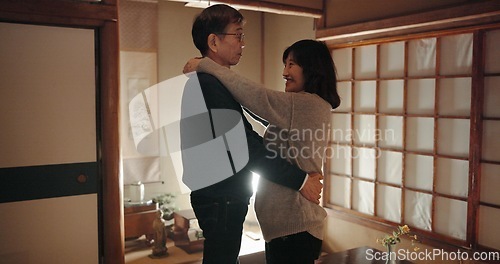 Image of Mature couple, dancing and home with love, smile and happiness with weekend break, hug and bonding together. Japanese people, man and woman embrace, apartment and cheerful with peace and support