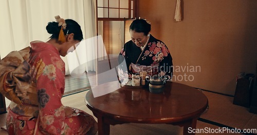 Image of Culture, home and Japanese women with tea, leaves and herbs in traditional tearoom. Friends, ceremony and people bow with herbal beverage for wellness, mindfulness and detox for drinking ritual