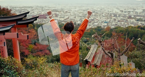 Image of Man, fist celebration and mountain with view, city and torii gates at Fushimi Inari shrine for shinto religion. Person, hiking and cheers by trees, pillar or achievement on spiritual journey in Kyoto