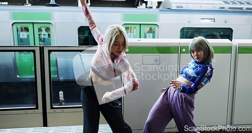 Image of Asian woman, dancing and street performance by railway station for energy or art in underground subway. Female person, friends or hip hop dancers in Japan, practice or training together by transport