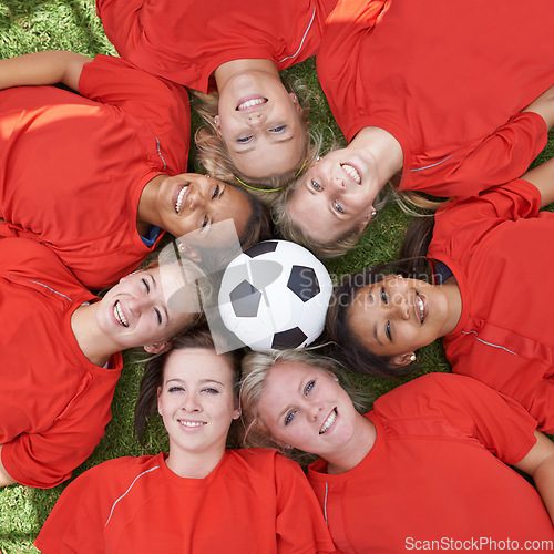 Image of Happy woman, soccer ball and face of team above for unity, collaboration or synergy lying on green grass. Top view or portrait of female person, group or football players smile on outdoor field