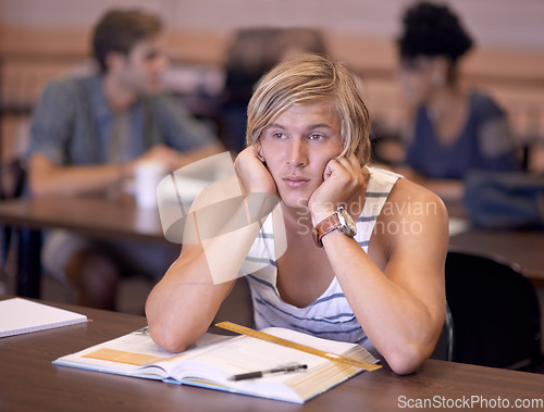 Image of Man, student and bored with book for studying, education or learning in library or classroom at college. Distracted young male person or learner with study notes or textbook for literature or reading