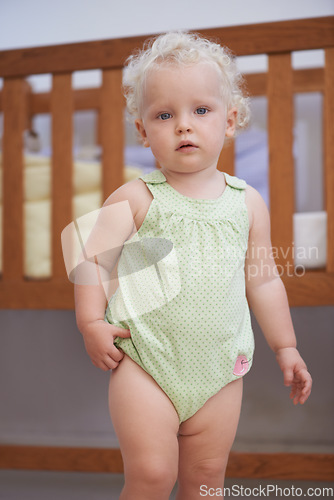 Image of Portrait, baby and kid at nursery in home, adorable and cute innocent child alone in house. Young blonde toddler, health and childhood development for growth of girl standing by crib in Switzerland