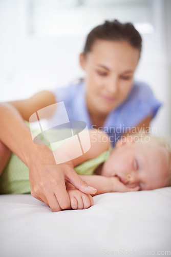 Image of Hands, sleeping and mom with baby on bed for bonding, relax and sweet cute relationship. Happy, smile and young mother watching girl child, kid or toddler taking a nap in bedroom or nursery at home.