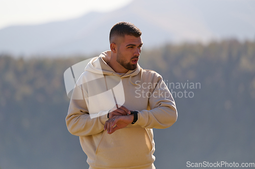 Image of Athletic man maintains his healthy lifestyle by running through the scenic mountain and lakeside environment, showcasing a commitment to fitness and well-being