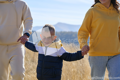 Image of A modern family, along with their son, revels in the joy of a muddy day in nature, running and playing together, encapsulating the beauty of a healthy and active lifestyle