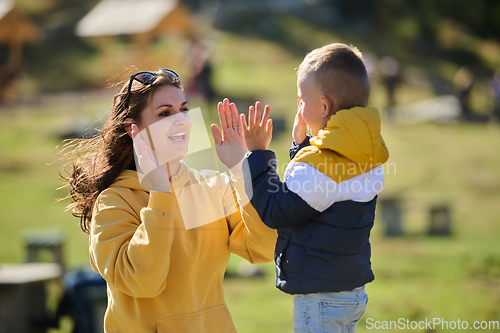 Image of A mother and son create cherished memories as they playfully engage in outdoor activities, their laughter echoing the joy of shared moments and the bond between parent and child