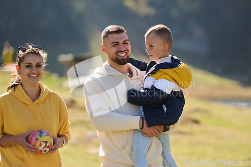 Image of A modern family, along with their son, revels in the joy of a muddy day in nature, running and playing together, encapsulating the beauty of a healthy and active lifestyle