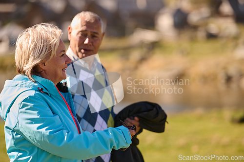 Image of Elderly couple strolling through the breathtaking beauty of nature, maintaining their vitality and serenity, embracing the joys of a health-conscious and harmonious lifestyle
