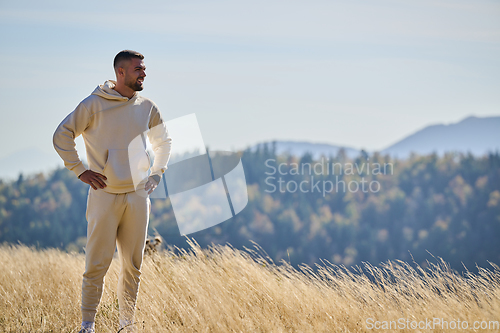 Image of A handsome man maintains his healthy lifestyle as he runs along beautiful natural trails, embodying the essence of fitness, wellness, and vitality in the midst of scenic outdoor surroundings.