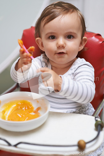 Image of Baby, high chair and food in bowl for meal, nutrition or healthy porridge with spoon at home. Portrait of young cute little child, kid or toddler playing with snack for hunger, vitamins or nutrients