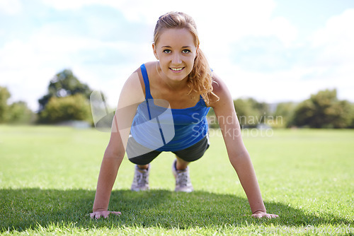 Image of Women, face and push ups on grass for fitness with exercise, training and workout on sports field. Athlete, person and confidence on ground with physical activity for healthy body or wellness outdoor