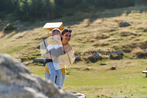 Image of A mother and son create cherished memories as they playfully engage in outdoor activities, their laughter echoing the joy of shared moments and the bond between parent and child