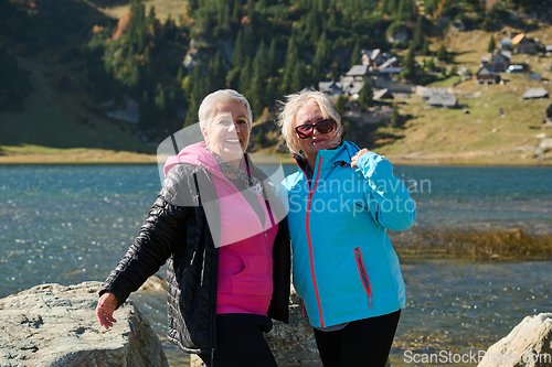 Image of Senior women hikers standing on mountain enjoying a trekking day - Smiling climbing tourists enjoying holidays and healthy lifestyle - Freedom, success sport concept