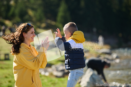 Image of A mother and son create cherished memories as they playfully engage in outdoor activities, their laughter echoing the joy of shared moments and the bond between parent and child