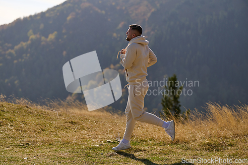 Image of A handsome man maintains his healthy lifestyle as he runs along beautiful natural trails, embodying the essence of fitness, wellness, and vitality in the midst of scenic outdoor surroundings.
