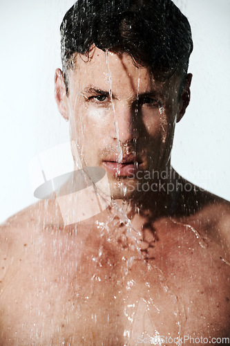 Image of Portrait of man in shower to relax, cleaning hair and body for morning wellness, hygiene or routine. Grooming, skincare and serious face of male model washing in water, self care and calm in bathroom