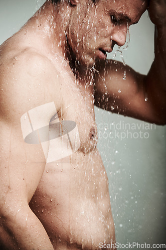 Image of Man in shower thinking, cleaning hair and body for morning wellness, hygiene and skin routine. Grooming, skincare and male model with muscle washing with water, self care and relax in calm bathroom.