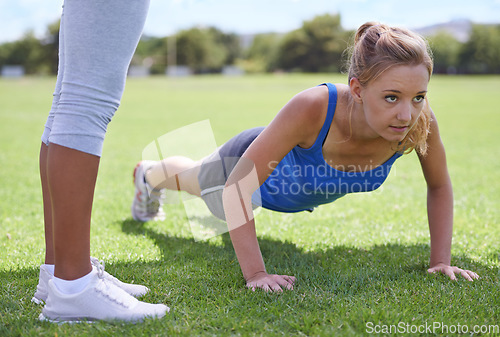 Image of Women, face and push ups on grass for exercise with fitness, training and workout on sports field. Athlete, person and confidence on ground and coach or physical activity for healthy body or wellness