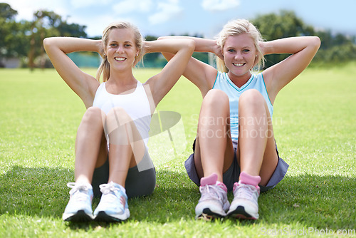 Image of Women, sit ups on grass outdoor for fitness with portrait, smile and wellness with confidence and sportswear. Athlete, friends and collaboration on sports field for physical activity, abdomen or core