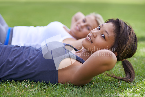 Image of Happy woman, portrait and sit ups for outdoor exercise or workout in fitness together on green grass. Young active female person or people smile for training, health and wellness on field in nature