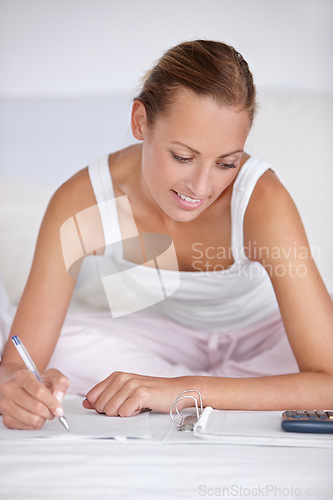 Image of Happy woman, writing and documents in bed for budget planning, expenses or finance at home. Female person smile with notebook or calculator for morning or financial checklist in bedroom at house