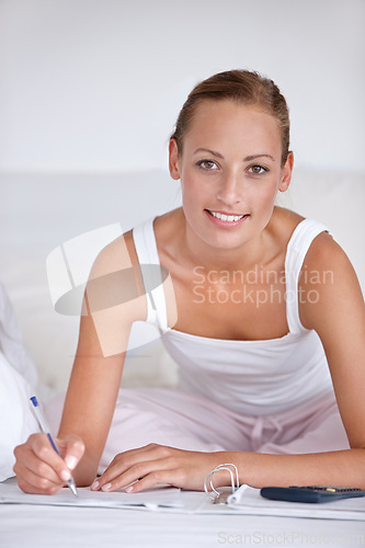 Image of Happy woman, portrait and writing on bed for budget planning, expenses or finance with documents at home. Female person smile with notebook or calculator for morning or financial checklist in bedroom