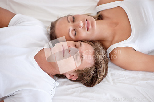 Image of Sleeping, love and young couple on bed in modern apartment relaxing together in the morning. Happy, calm and man and woman in marriage taking comfortable nap for dreaming in bedroom at home or house.