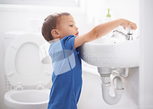 Image of Child, boy and washing hands in bathroom, hygiene and prevention of germs or bacteria at home. Male person, kid and learning at basin or cleaning and sanitary care, water and disinfection for safety