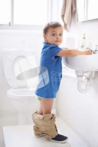 Image of Child, boy and washing hands in portrait, hygiene and prevention of germs or bacteria in bathroom. Male person, kid and crazy humor or funny joke while potty training, cleaning and sanitary care