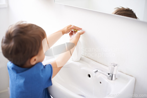 Image of Child, boy and liquid soap for washing hands in bathroom, hygiene and prevention of germs or bacteria at home. Male person, kid and learning at basin or cleaning and sanitary, water and disinfection